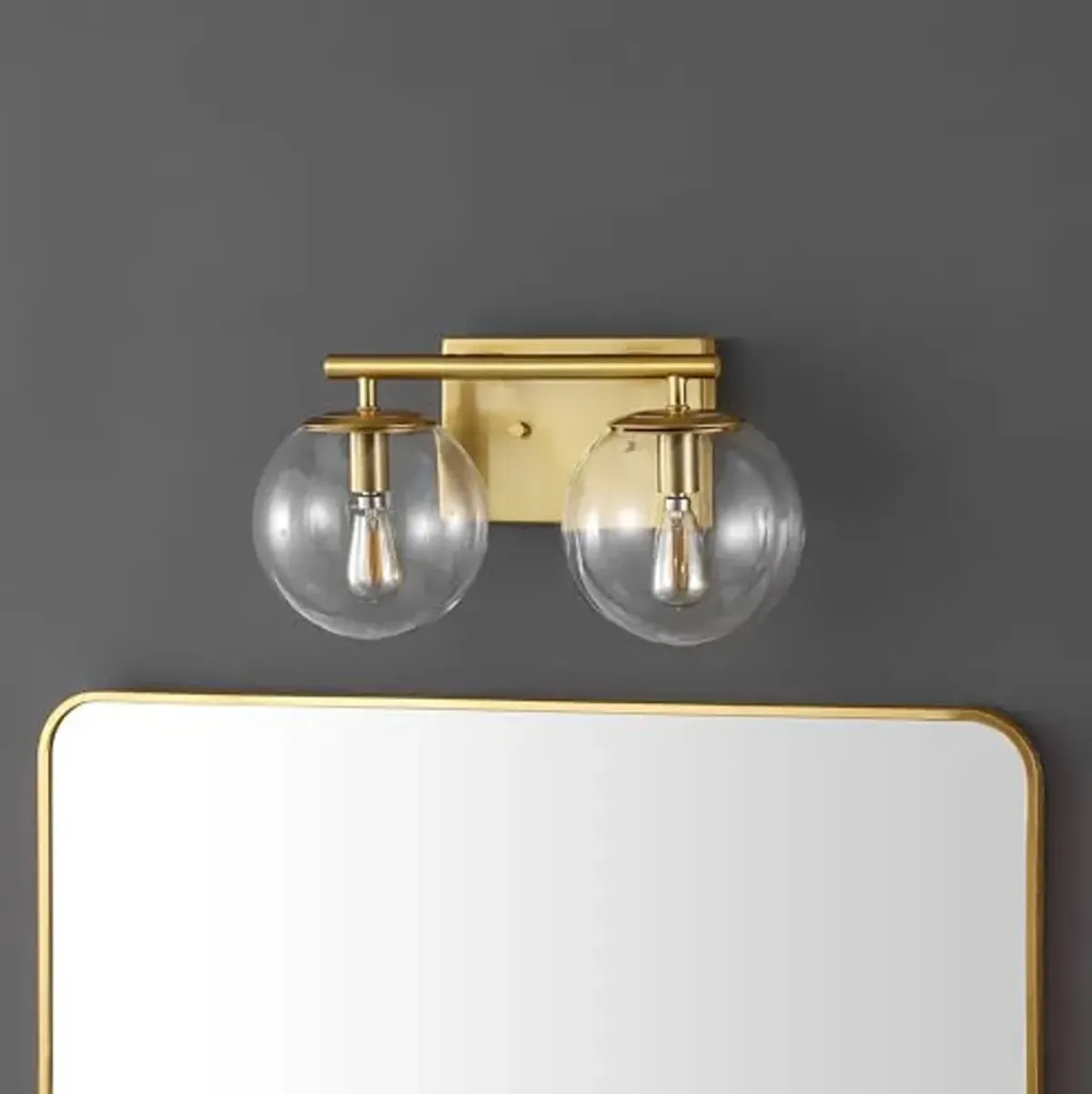 SAFAVIEH Lighting Collection Severa Brass/Clear Glass Globe Shade 2-Light Wall Sconce Light Fixture, Ideal for Bathroom, Entryway, Vanity, Foyer, Hallway, Living Room (LED Bulb Included)