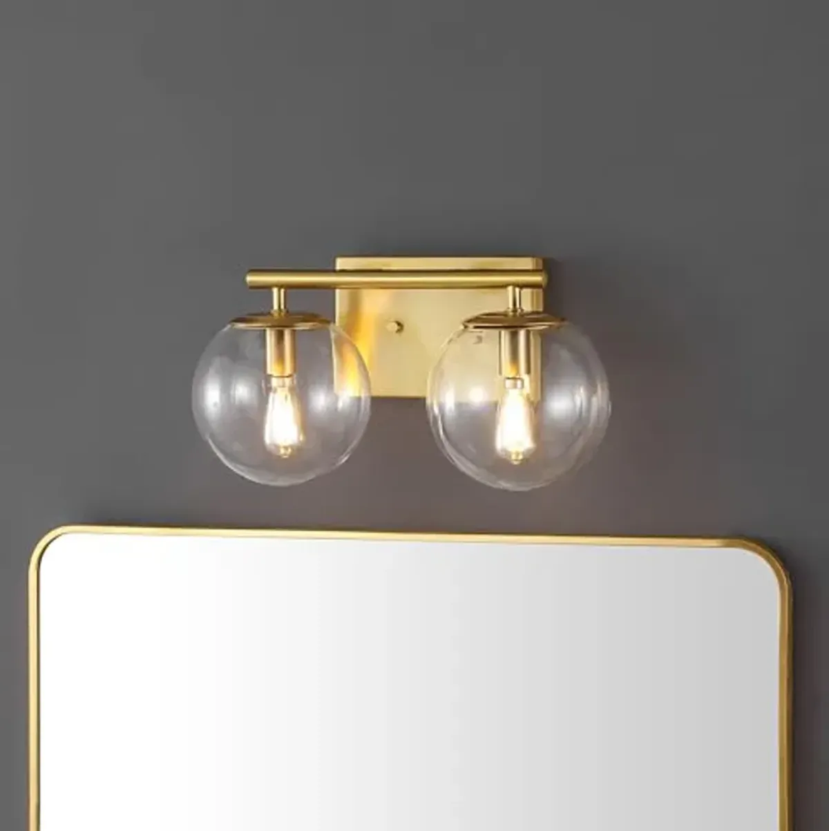 SAFAVIEH Lighting Collection Severa Brass/Clear Glass Globe Shade 2-Light Wall Sconce Light Fixture, Ideal for Bathroom, Entryway, Vanity, Foyer, Hallway, Living Room (LED Bulb Included)