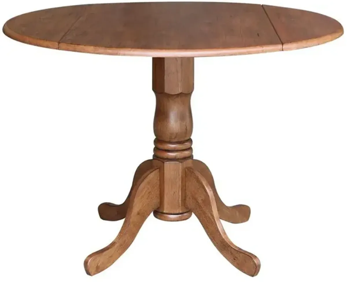 John Thomas Dining Essentials Round Drop Leaf Pedestal Table in Bourbon Oak